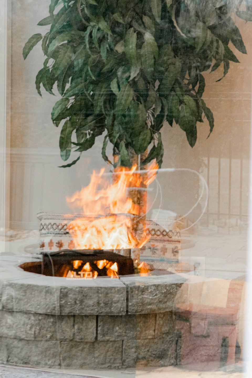 A fire burns inside a stone patio fire pit.